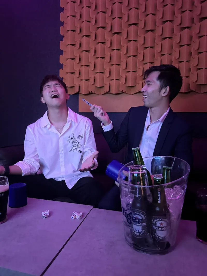 Friends laughing over dice games in a KTV room