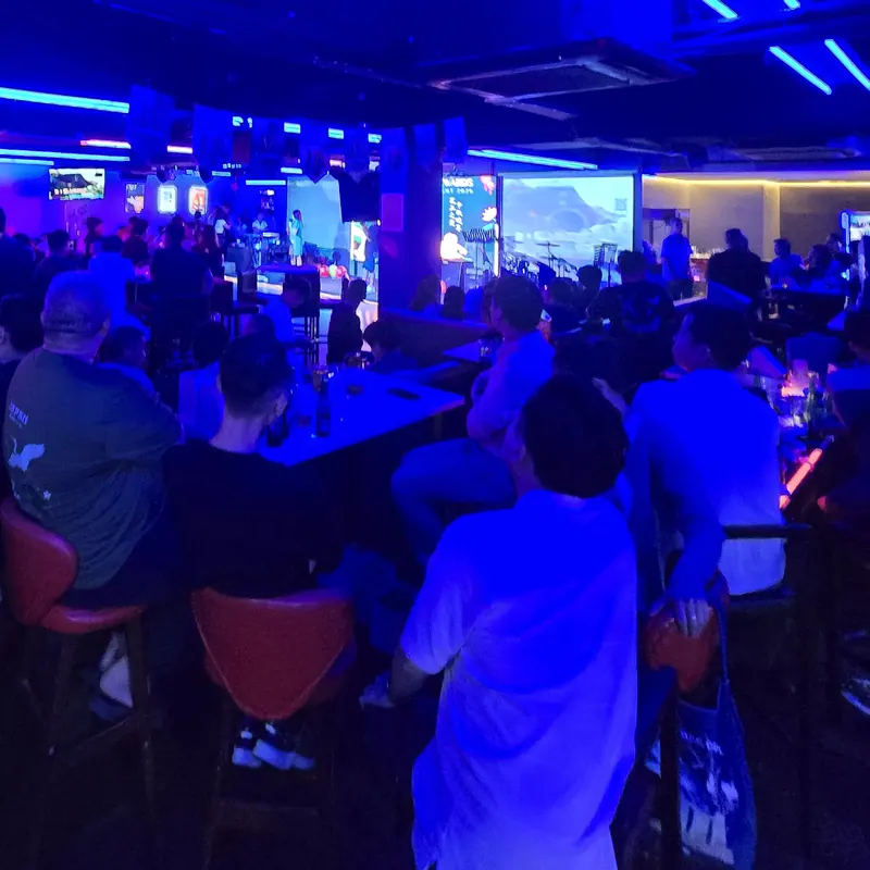 Guests watching the stage at an evening company event at Major 99, under blue neon lighting