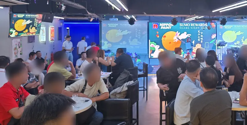 The Major 99 main hall full for a company night, with guests at tables and the stage and LED screens behind